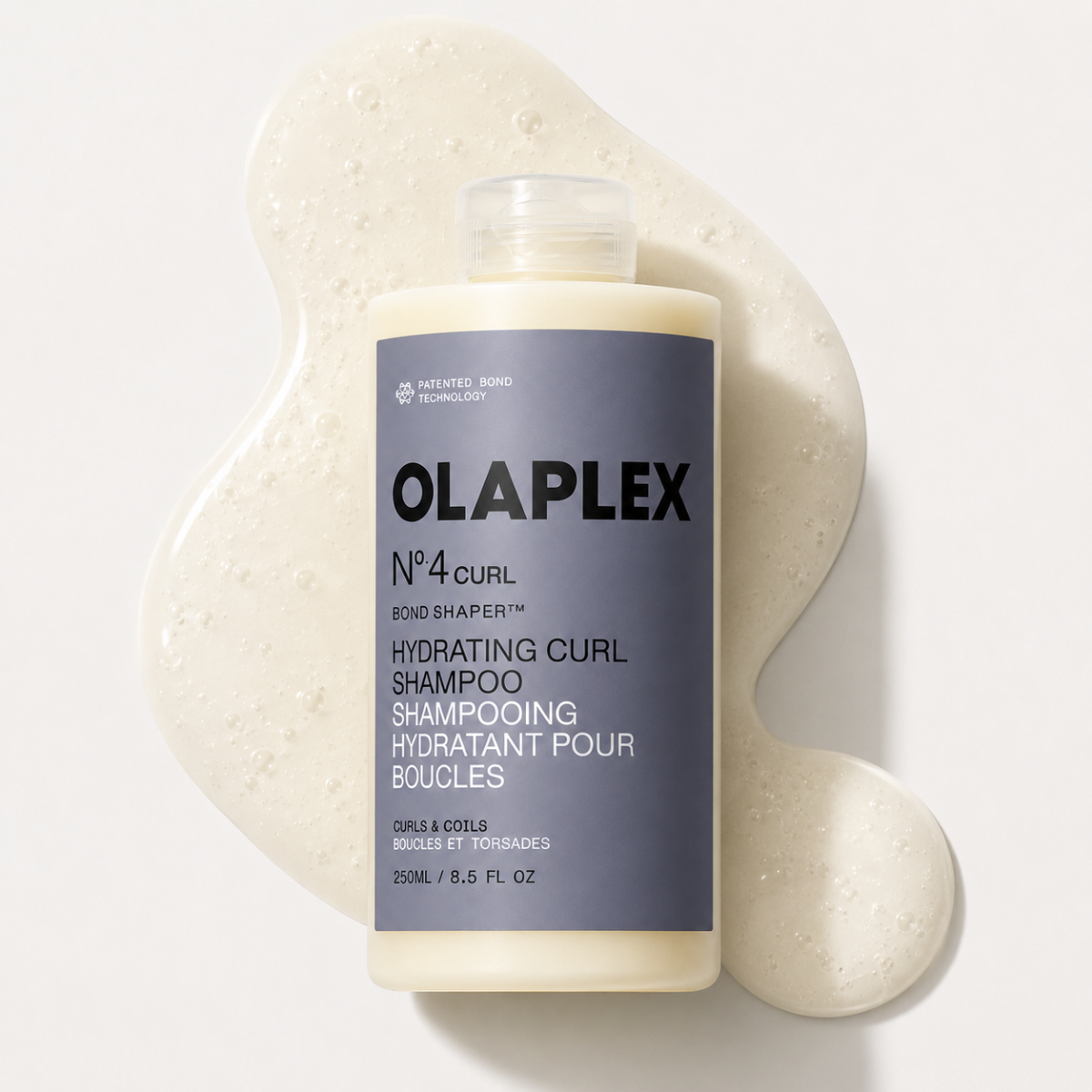 Olaplex shampoo bottle with a gray label with light-beige product behind it on a white background