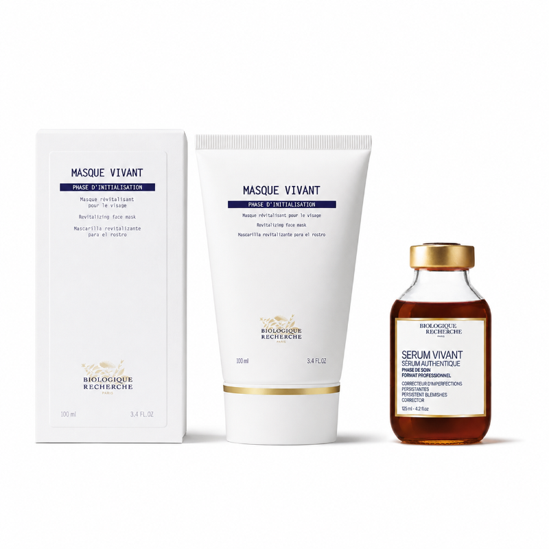 Picture features Biologique Recherche Serum Vivant glass bottle and Masque Vivant tube next to box on a white background. The box and tube have the same logo and blue text, with the tube featuring a gold highlight. The Biologique Recherche Serum Vivant bottle contains an amber colored liquid and has a gold cap. The white bottle label has a gold border with blue product text.