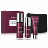maroon skincare products in front of maroon box and black bag on white background