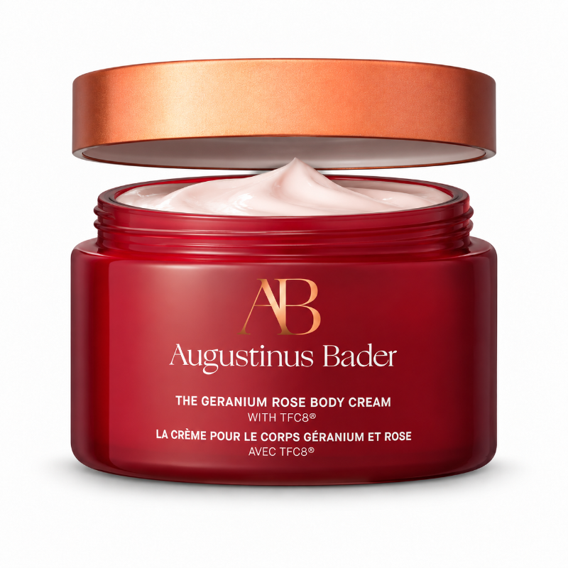 Red and Bronze Augustinus Bader cream container with white/gold text reading "The Geranium Rose Body Cream with TFC8" The cap is detached exposing white cream inside